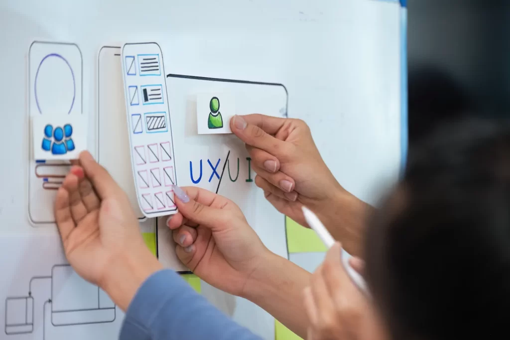 Wireframes impresos sobre una mesa durante una sesión de ideación UX.