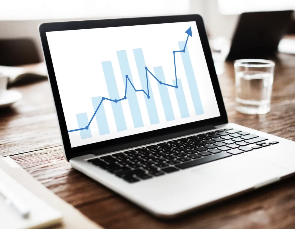 Gráfica de crecimiento en pantalla de laptop, señalando resultados positivos de posicionamiento.