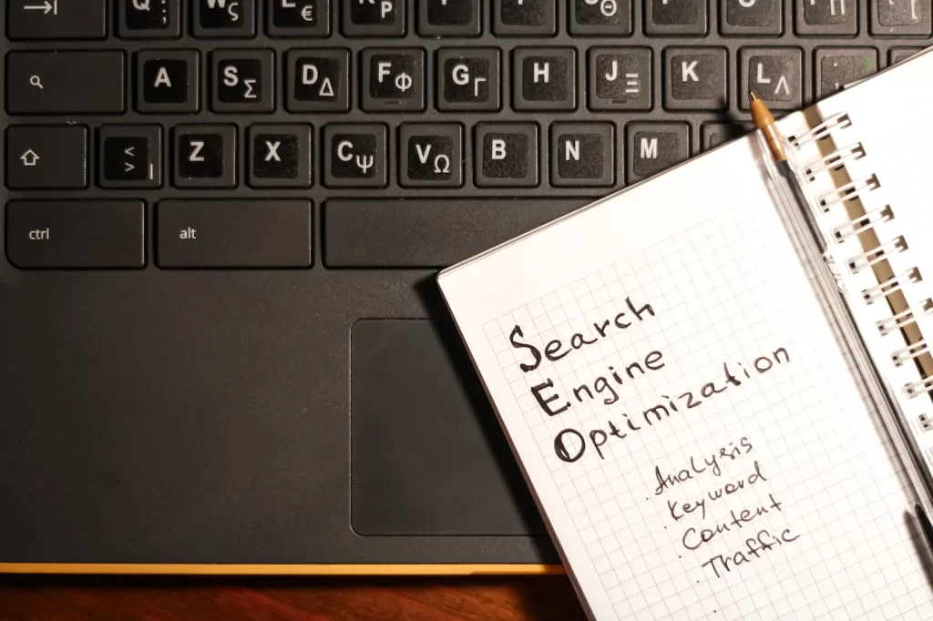 Cuaderno con notas de SEO junto a una laptop, destacando planificación de estrategias.